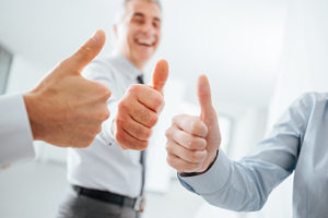 Cheerful business people thumbs up